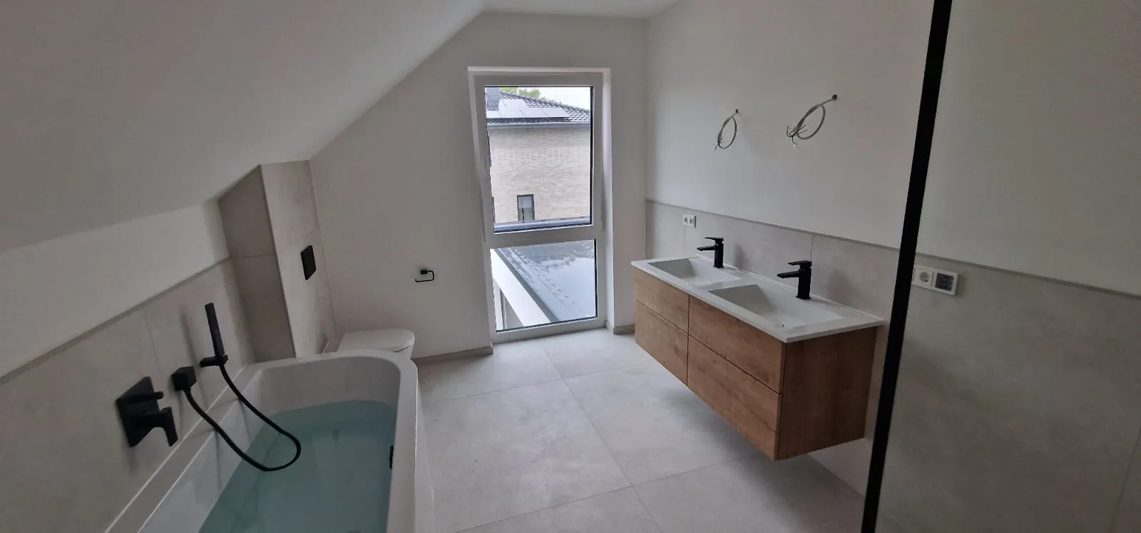 Badezimmer mit Dachschräge, Badewanne und Fenster
