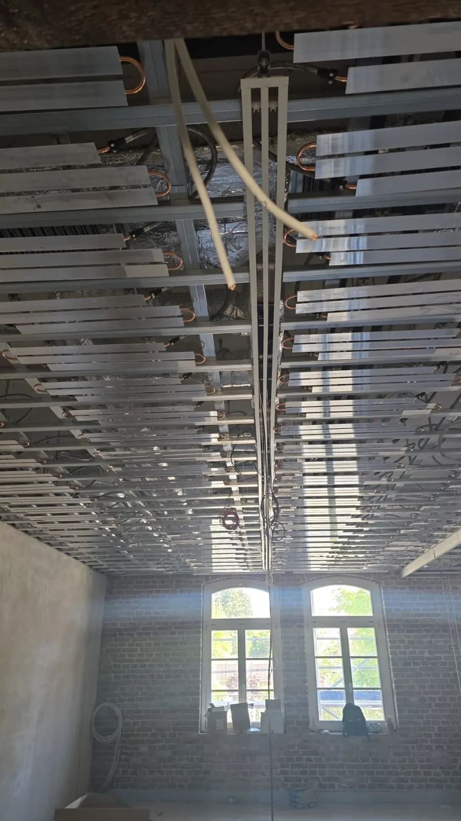 Deckenunterkonstruktion mit Fensterfront im Hintergrund
