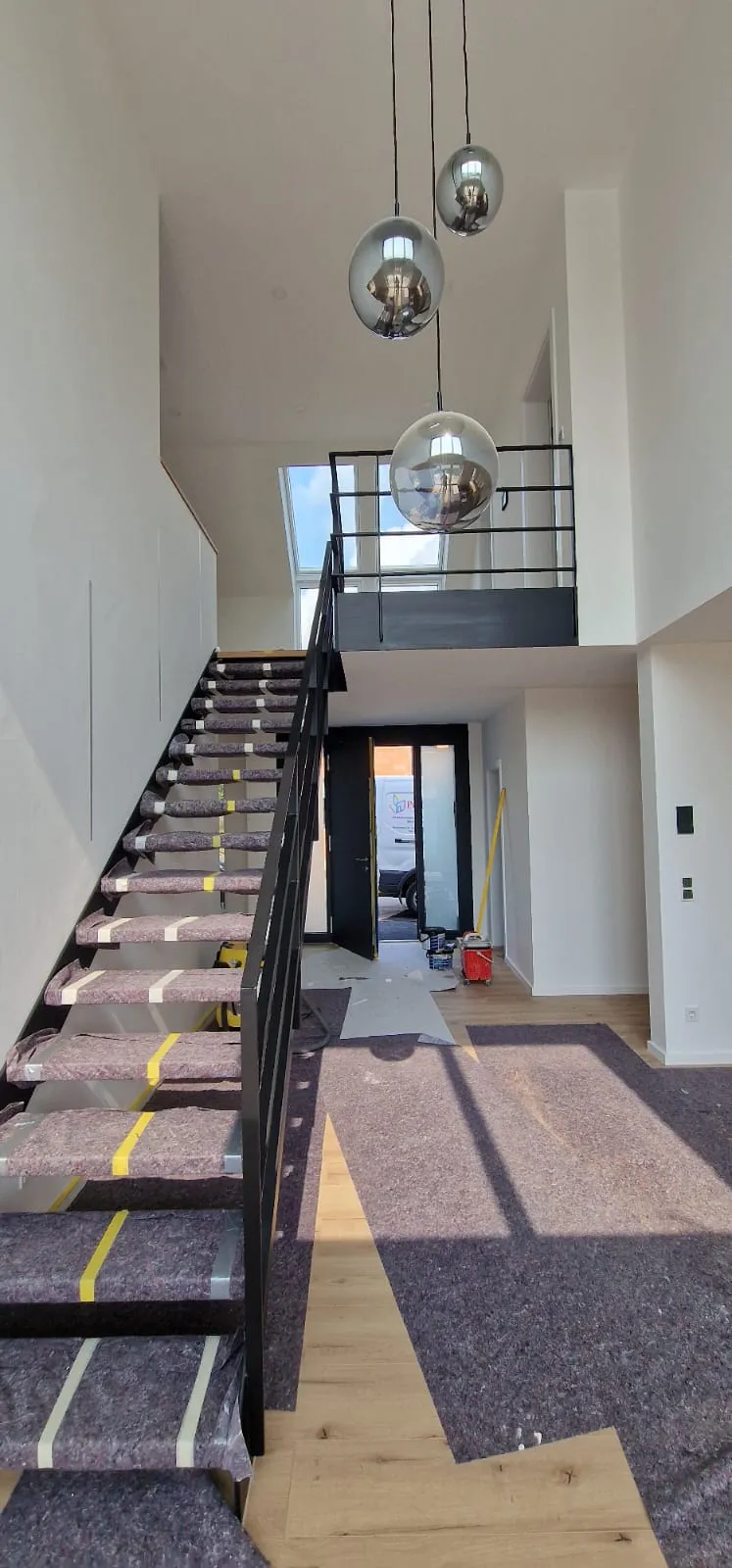 Offener Wohnraum mit Parkettboden und Treppe